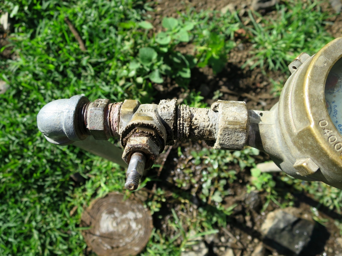 A leaky water meter wasting water in a water scarce town